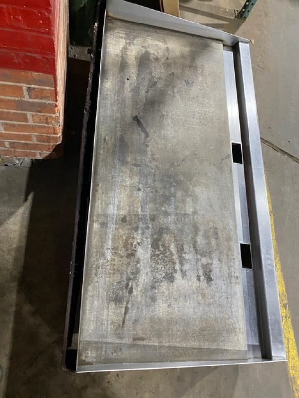 Vulcan commercial stainless steel countertop flat griddle with thermostatic control, back and side splash, on legs. Worn surface.