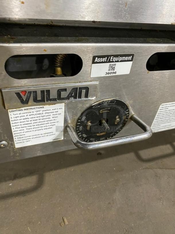 Vulcan commercial stainless steel natural gas flat griddle with thermostatic control, back and side splash, on legs.