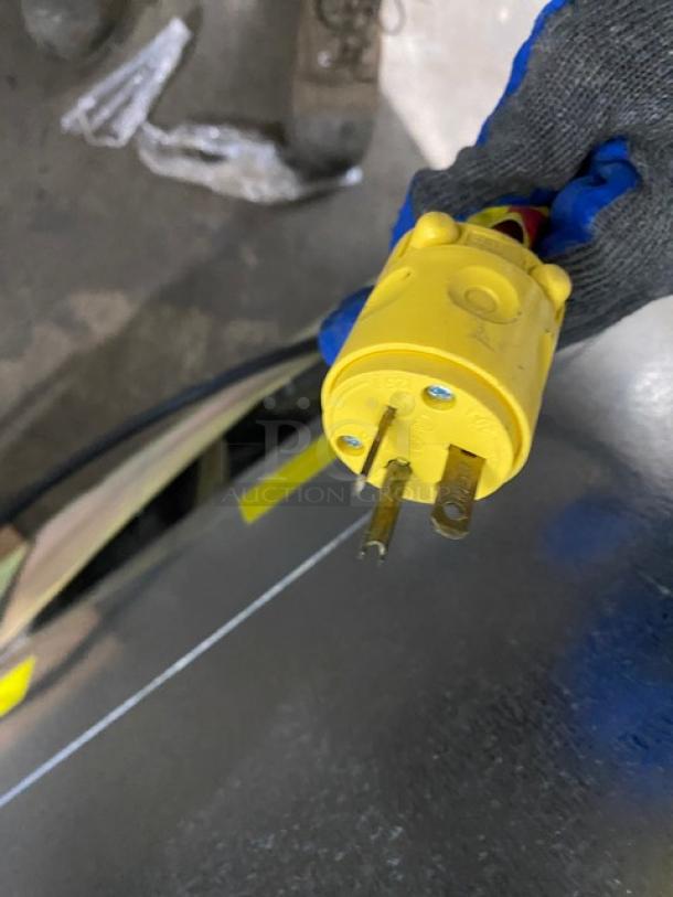 Yellow power plug from an Ojeda ALPA120G2 refrigerated display case, highlighting electrical connection details.