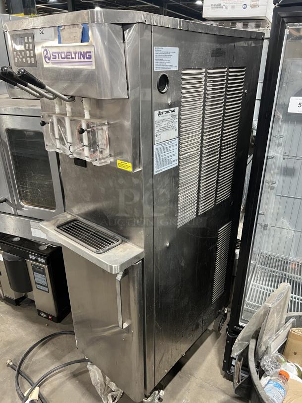 Stoelting stainless steel twin/twist soft serve machine, Model O431-10912F-R, with drip tray, 208-240V, 3 phase, on casters.