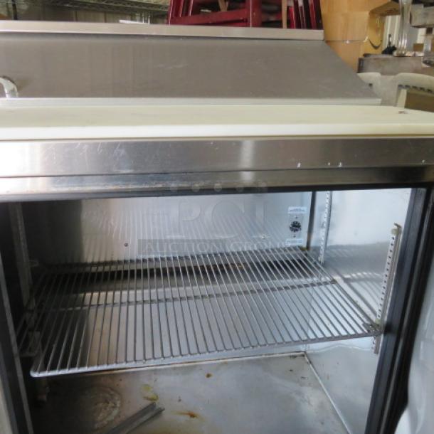 True TSSU-60-16 refrigerated prep table with cutting board, 2 racks, and casters. Measures 60x30x43 inches, 115V.