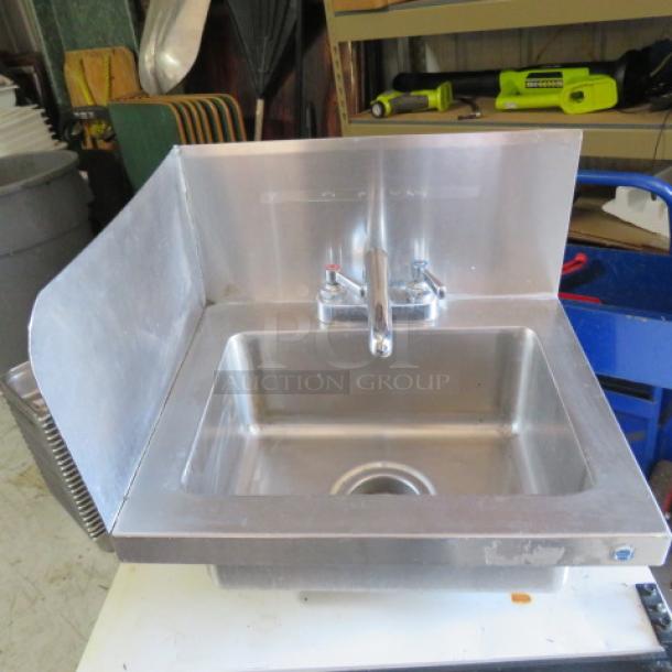 Stainless steel hand sink with faucet, left side, and back splash. Includes dual handles. Suitable for commercial use.
