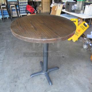 Round 2-inch thick solid wooden table top on a bar height pedestal base, measuring 30x30x37 inches. Durable, rustic design.