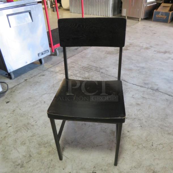 Black metal and wooden chair, features sturdy frame, minimalistic design. Visible wear on seat. Ideal for vintage decor.