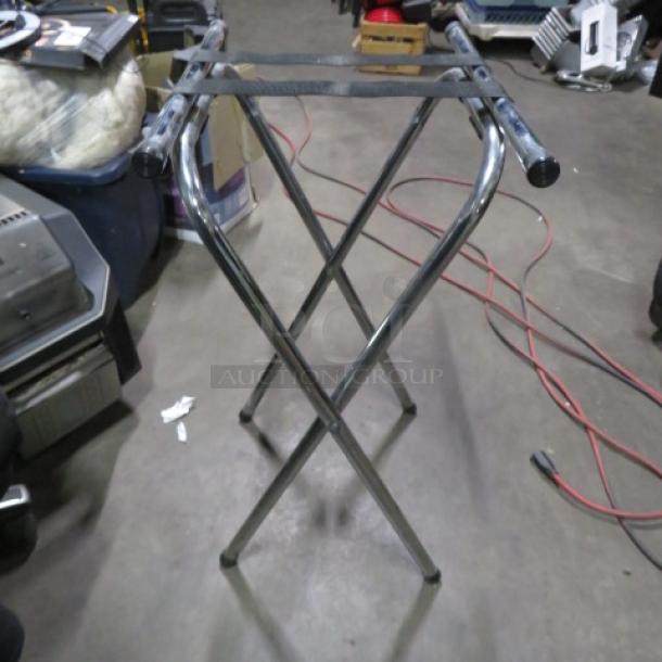 Stainless steel tray stand, foldable, durable, with sleek chrome finish. Good condition, no visible markings or labels.