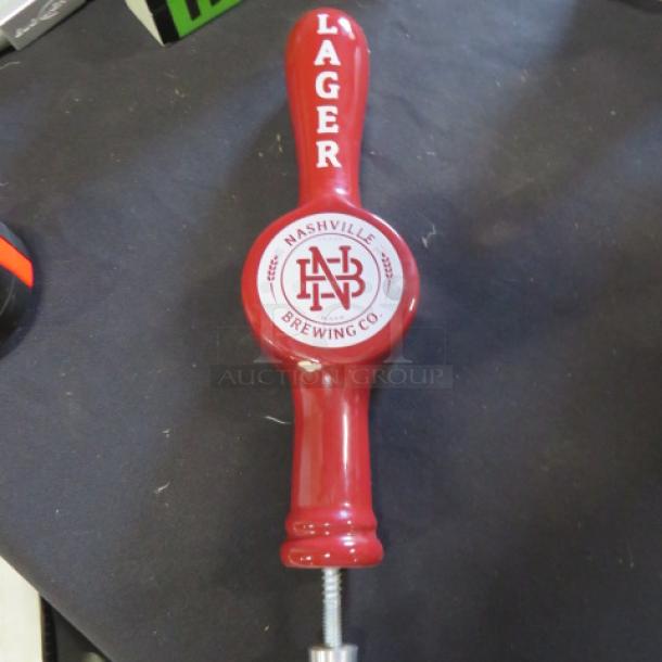 Red beer tap handle, Nashville Brewing Co., labeled "Lager." Features brewery's logo in good condition.