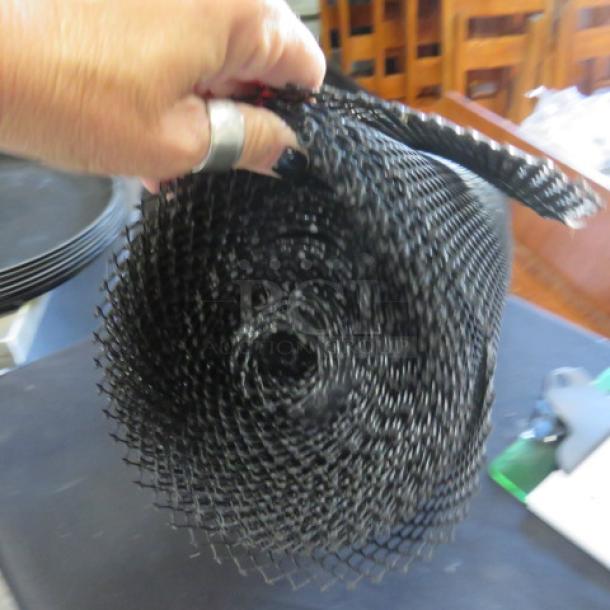 Mega roll of black bar netting, tightly rolled, in excellent condition. Hand holding the netting emphasizes flexibility and texture.