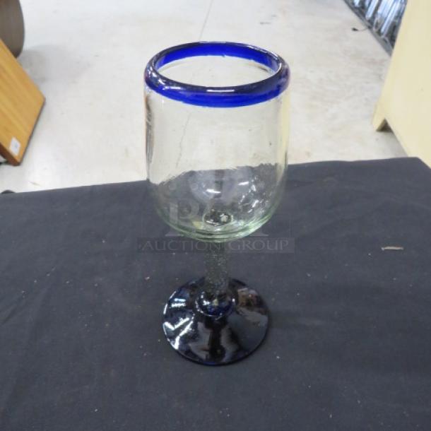 Beautiful wine glass with a vibrant blue rim and a textured stem. Elegant design, excellent condition, model 7XBID.