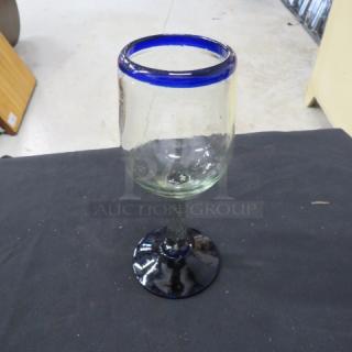 Beautiful wine glass with a vibrant blue rim and a textured stem. Elegant design, excellent condition, model 7XBID.