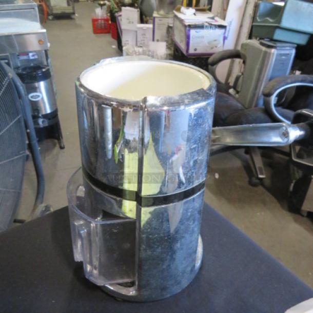 Chrome juicer with handle, vintage design, some wear visible. Includes clear plastic juice collector.