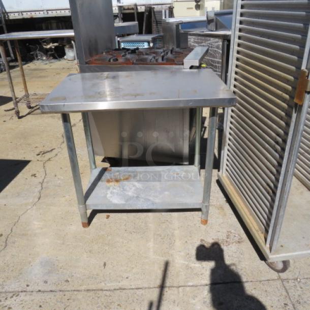Stainless steel table with under shelf, size 36x24x33.5 inches, used condition, surface rust on legs.