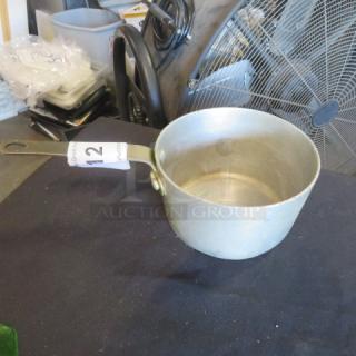 1.5 quart aluminum sauce pan with long handle, gently used. Auction tag marked "12" attached to handle.