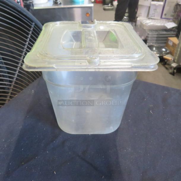 1/6 size, 6-inch deep food storage container with lid. Transparent plastic, condition appears used. Suitable for commercial kitchen use.