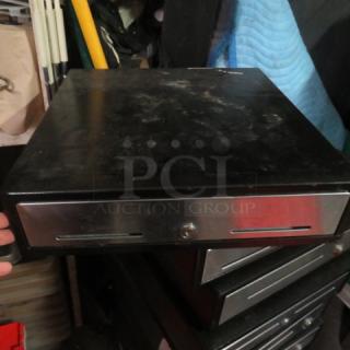 Black metal cash drawer with a stainless steel front, including a key lock and two bill slots. Visible signs of wear.