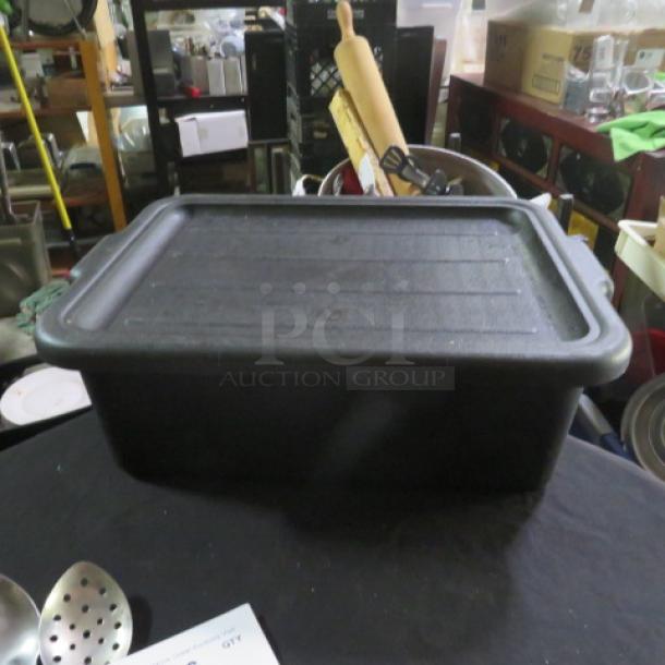 Black bussing tub with lid, rectangular, used condition, suitable for storage or transport.