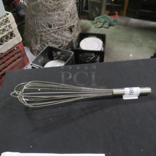 Stainless steel whip, wire balloon style, with a cylindrical handle. Tag labeled "682" attached.