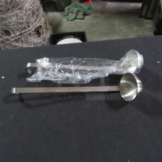 New stainless steel 2oz ladle, two shown. One wrapped in plastic, another exposed. Ideal for precise serving.