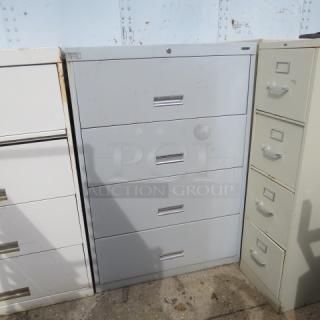 Gray 4-drawer file cabinet, 36x18x52 inches, metal, used condition, secure lock mechanism, suitable for office storage.