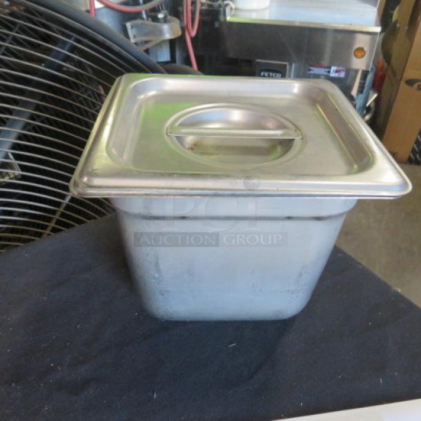1/6 size, 6-inch deep hotel pan with lid; stainless steel; used condition; commercial kitchen equipment.