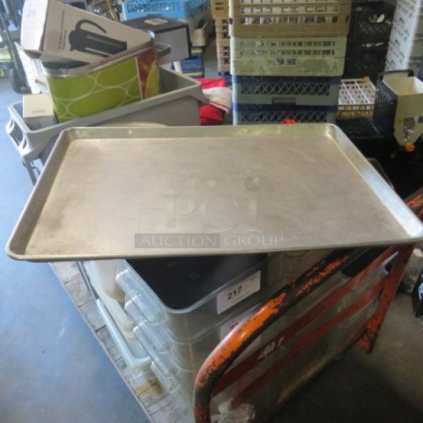 Full-size aluminum sheet pan, gently used, rectangular shape with raised edges, ideal for baking or roasting.