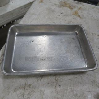 9.5x6.5-inch metal sheet pan in used condition, displaying surface wear and marks, suitable for baking or roasting.