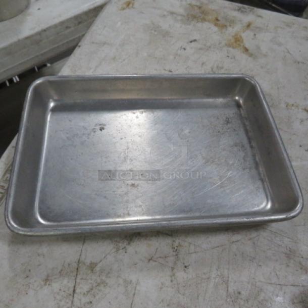 9.5x6.5 inch metal sheet pan with visible wear and scratches, in used condition. No visible brand markings.