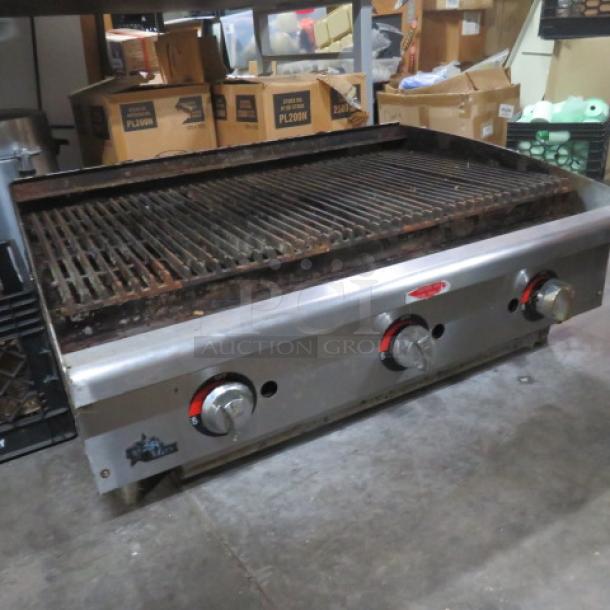 Star Max natural gas charbroiler, 36x26x15 inches. Features three control knobs, metal construction. Shows signs of wear.