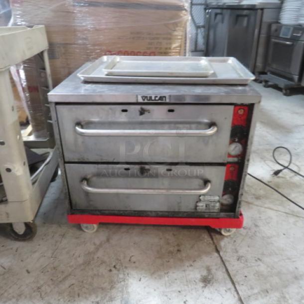 One Vulcan VW2S 2 Drawer Warmer, used, with power cord, 120 Volt, visible brand label, on four wheels.