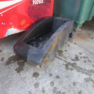 One Slim Jim Trash Can Dolly, black plastic, wheeled base, used condition with visible wear.