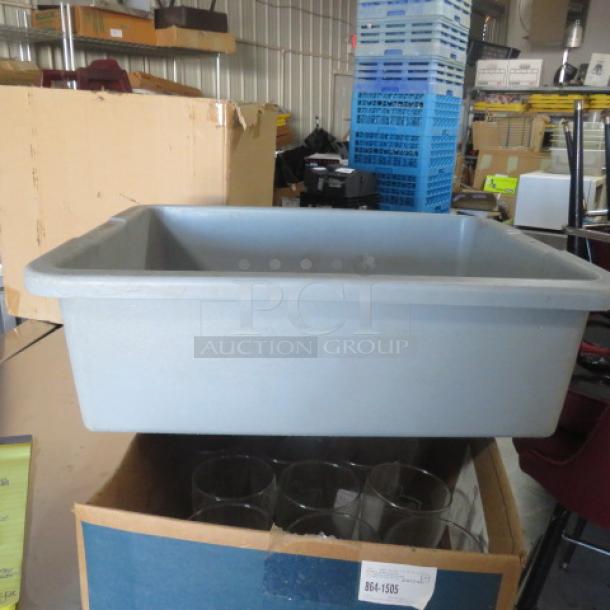 Gray plastic buss tub, rectangular, sturdy, used condition. Appears durable, ideal for clearing dishes in food service settings.