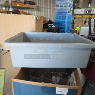 Gray plastic buss tub, rectangular, sturdy, used condition. Appears durable, ideal for clearing dishes in food service settings.