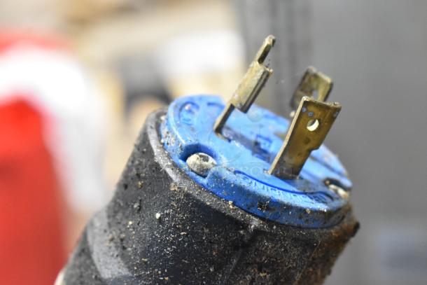 A close-up of a blue electrical plug with visible wear and dirt, likely part of the Middleby Marshall PS638G pizza ovens.