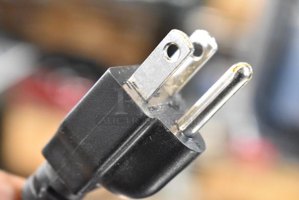 Close-up of a black electrical plug with three prongs for a Hobart HTi-SSLSC scale.