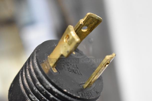 Close-up of a three-prong plug end for Schaerer Coffee Art Plus Espresso Machine. Plug shows wear, standard voltage use.