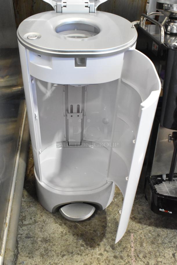 White diaper pail with open lid and door, showing clean interior. Foot pedal and sleek design enhance usability.