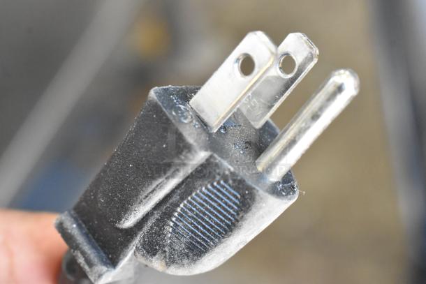 Close-up of a black plug for the 2021 Vita-Mix VM0145 commercial blender. The plug features a three-prong design.