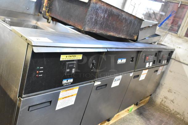 Giles EOF-24 stainless steel 3-bay deep fat fryer with center dumping, commercial casters, 480V, 3-phase, warning labels visible.