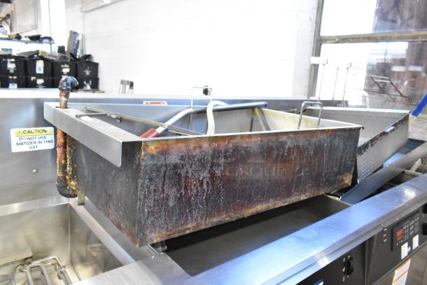 Giles EOF-24 stainless steel 3-bay electric fryer with center dumping station, commercial casters, visible caution label.
