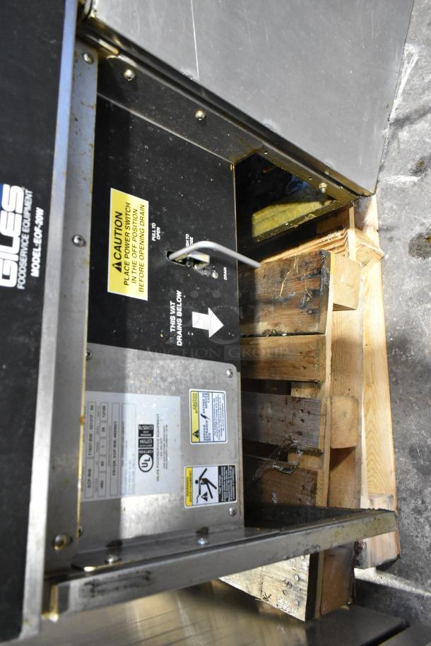 Giles EOF-24 stainless steel commercial 3-bay deep fat fryer with center dumping station, visible caution and operation labels.