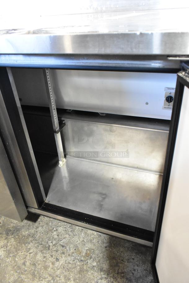 True TWT-72 stainless steel 3-door work top cooler with commercial casters, 115V, interior view, clean condition.
