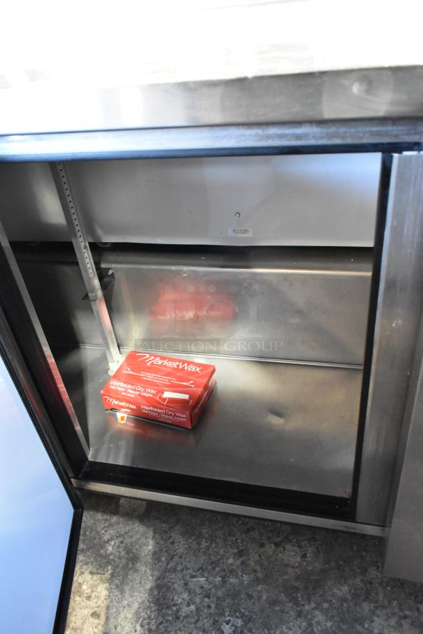 True TWT-72 stainless steel commercial work top cooler, 3 doors, on casters. Interior shows shelving and wax paper box.