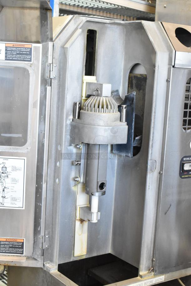 JBT Fresh N Squeeze POS-1 stainless steel commercial citrus juicer with internal components visible, on commercial casters.
