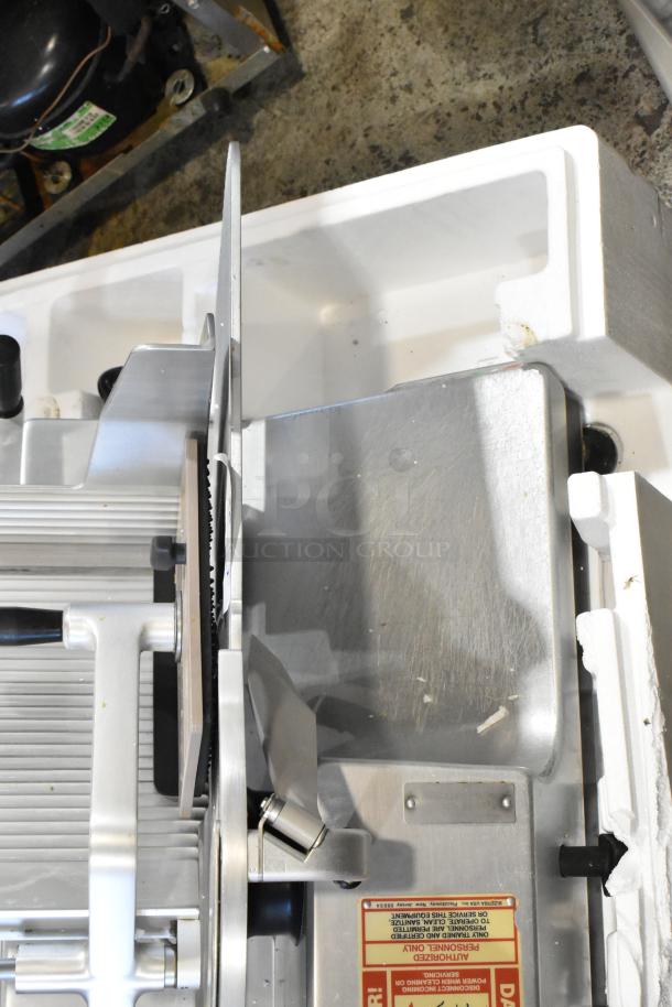 Bizerba SE12DUS metal commercial meat slicer, 120V, 1 phase, with visible safety warnings, shown on packaging.
