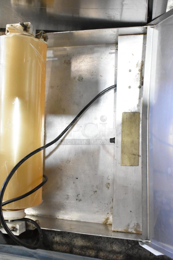 Metal countertop wrapping station, model 5000156, 115 volts, 1 phase. Visible wear, electrical cord attached.