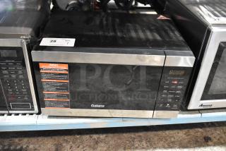 2020 Galanz GSWWD09S1A09A countertop microwave, black and stainless steel, 120V, with control panel and visible label.