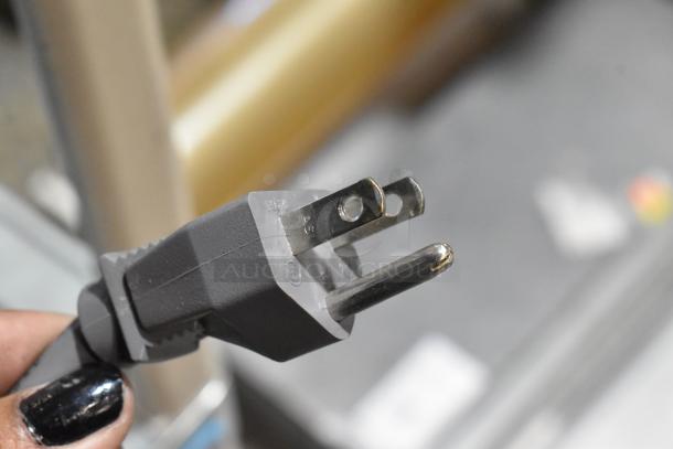Close-up of a three-prong power plug for a 2017 Amana RCS10TS Stainless Steel Commercial Microwave, 120 Volts, 1 Phase.