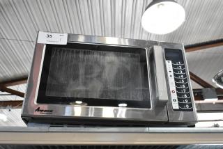 Amana RCS10TS stainless steel commercial countertop microwave oven, visible controls, model label, good condition.