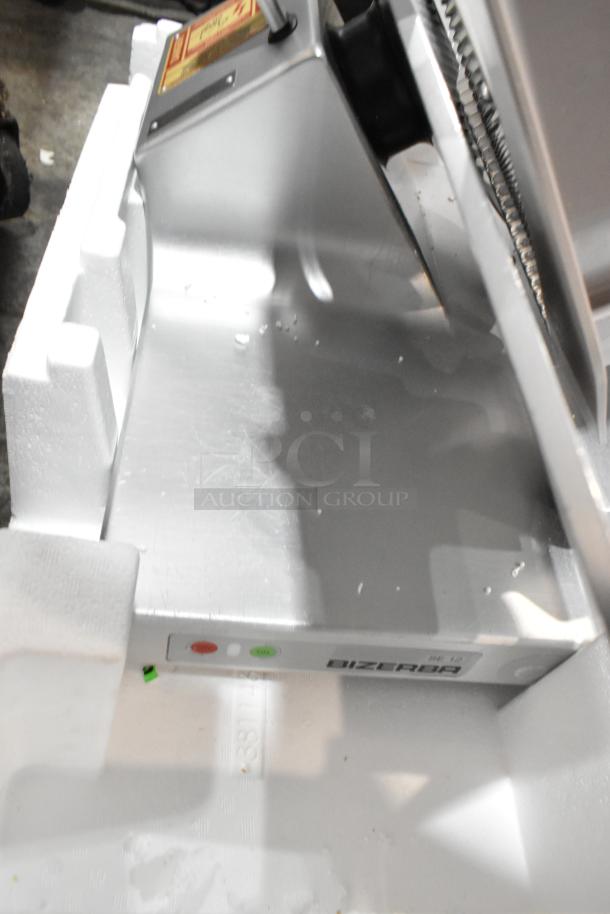 Bizerba metal commercial countertop meat slicer, 120 volts, 1 phase; visible brand marking on base, in Styrofoam packaging.