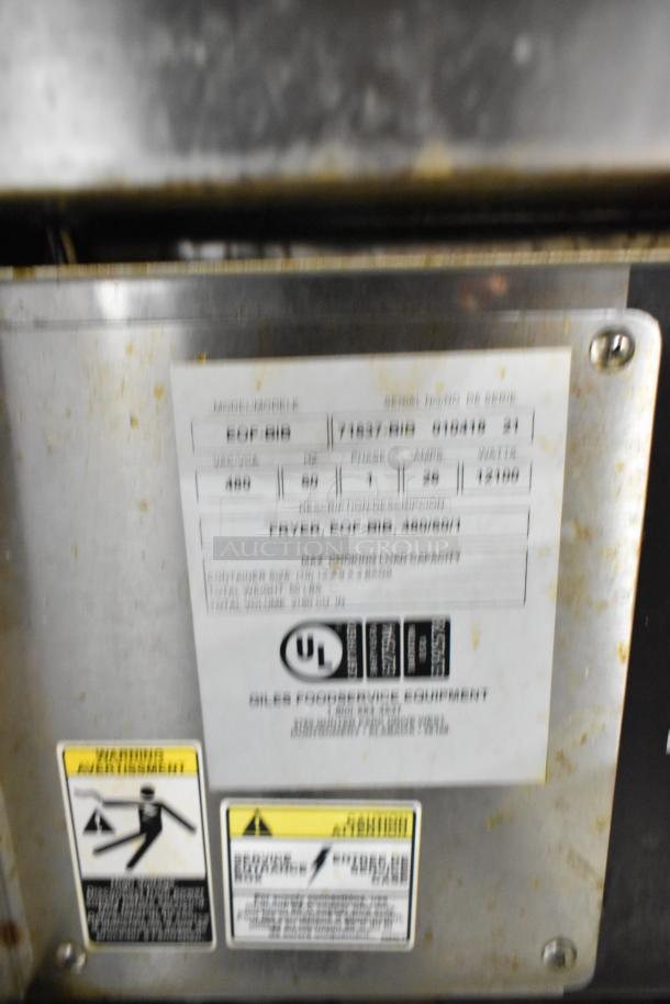 Giles EOF-24 stainless steel 3 bay fryer with center dumping, commercial casters, and label displaying specifications.