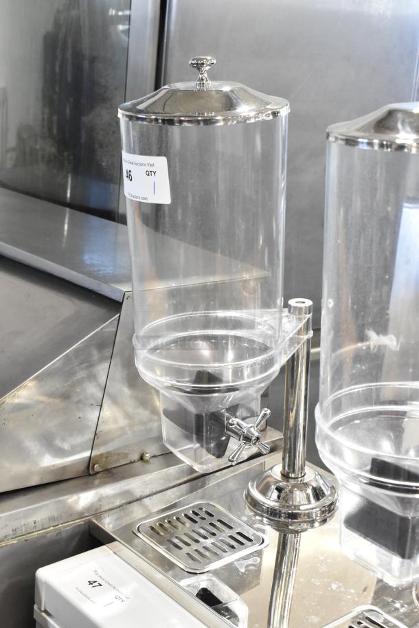 Chrome-finished dry goods dispenser with clear poly hoppers, brand new, minor scratches and dents, label indicates quantity one.